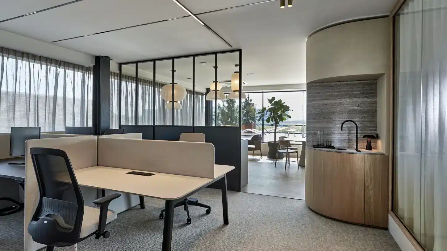 Modern kantoor met open werkplekken, akoestisch meubilair en zachte materialen die bijdragen aan een betere akoestiek op kantoor