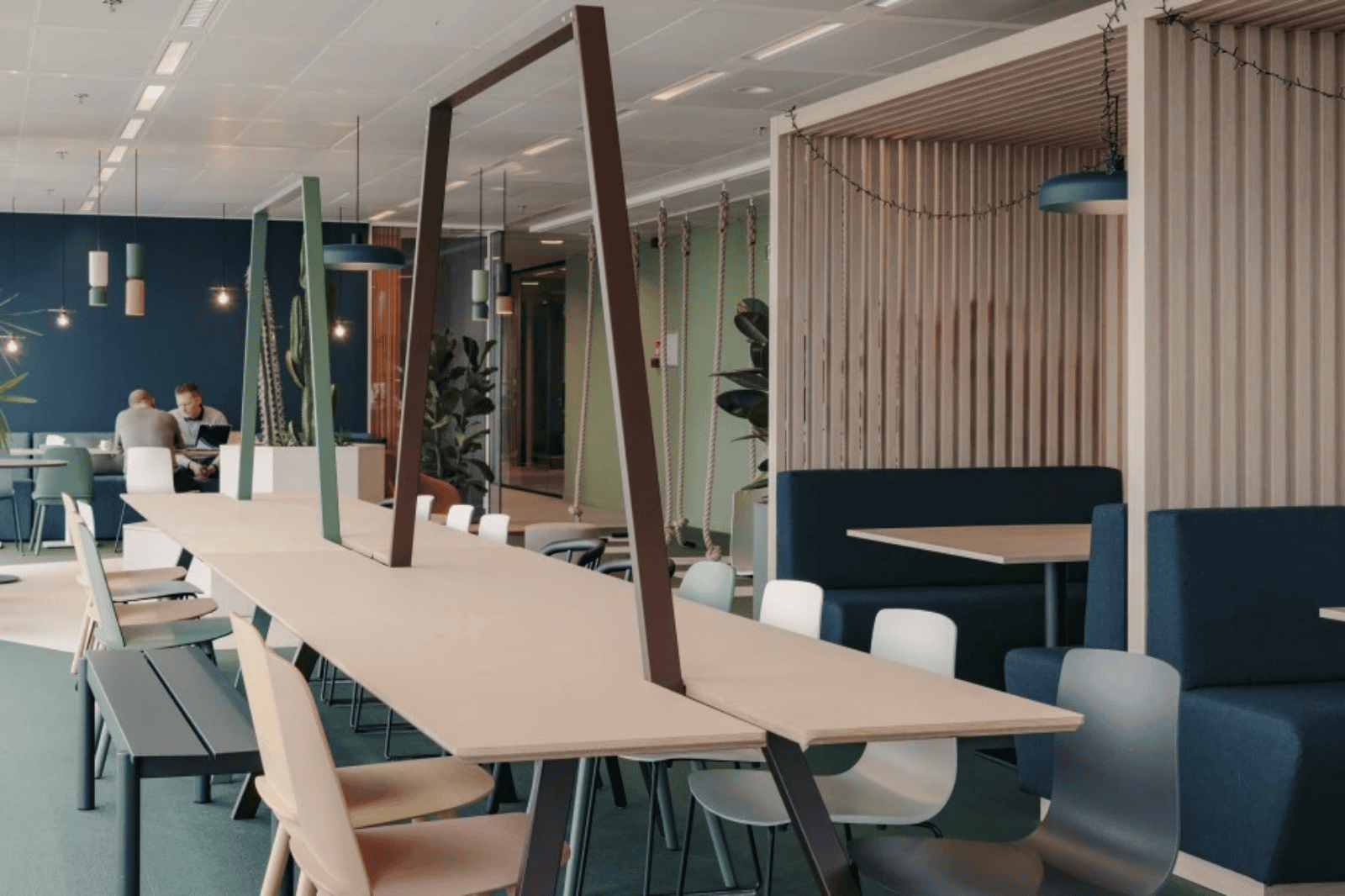 Espace de rencontre et de restauration créatif avec longue table, suspensions et sièges modernes