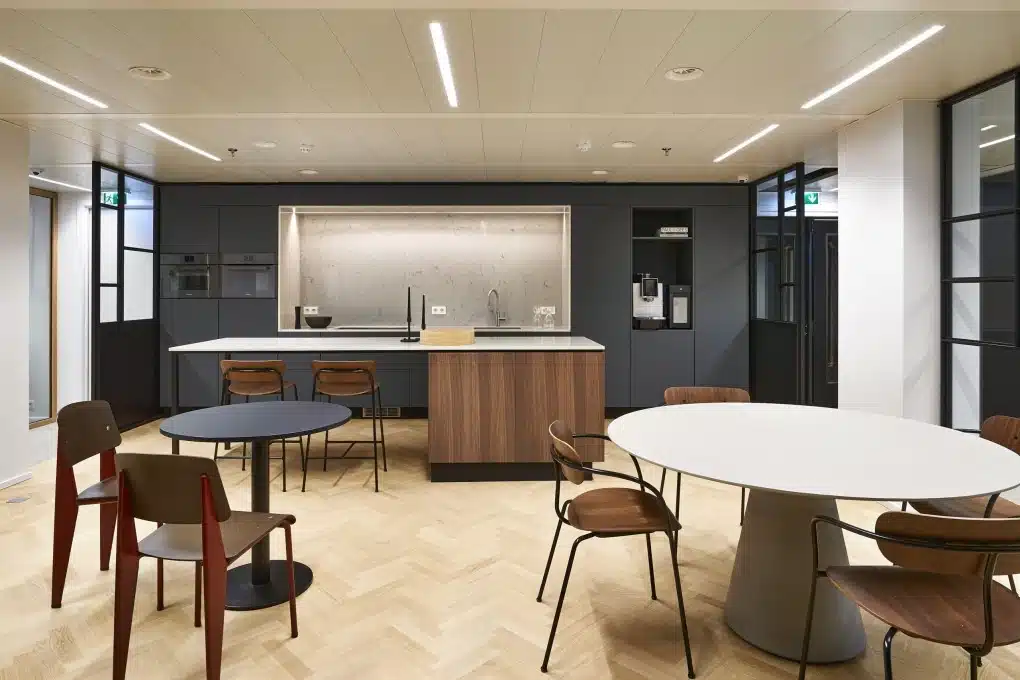 Cantine aménagée de façon moderne avec parquet, cuisine épurée et coin salon pour les employés et les clients