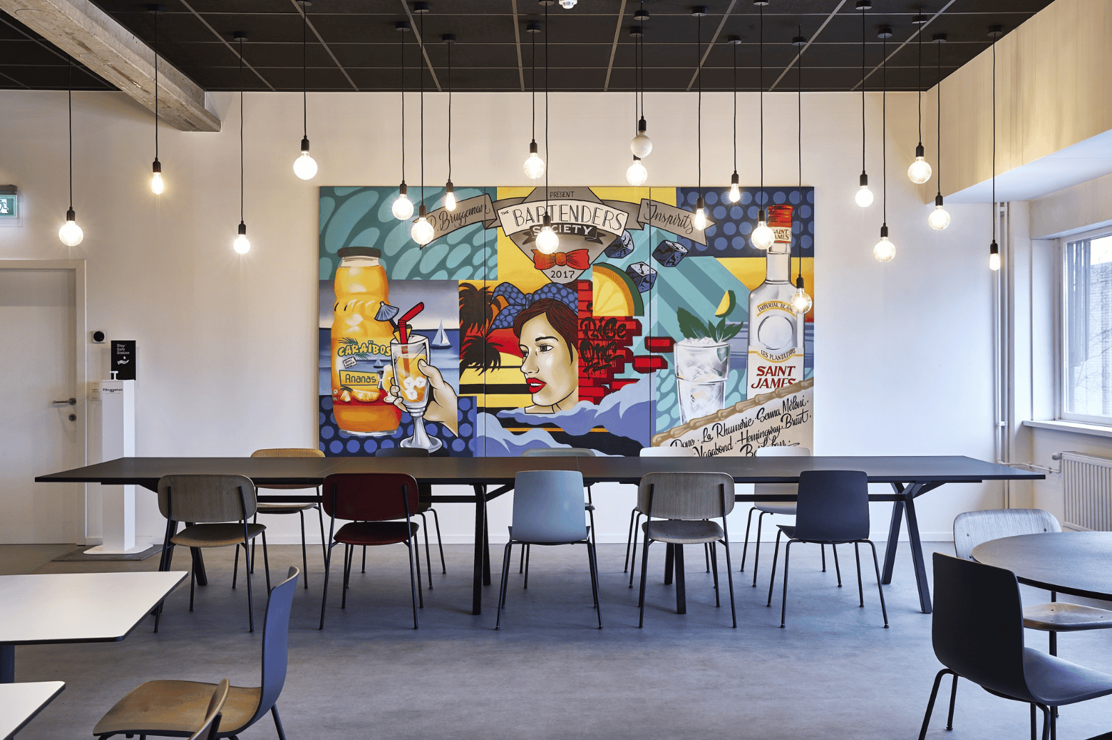 Cantine d'entreprise avec peinture murale colorée et aménagement moderne