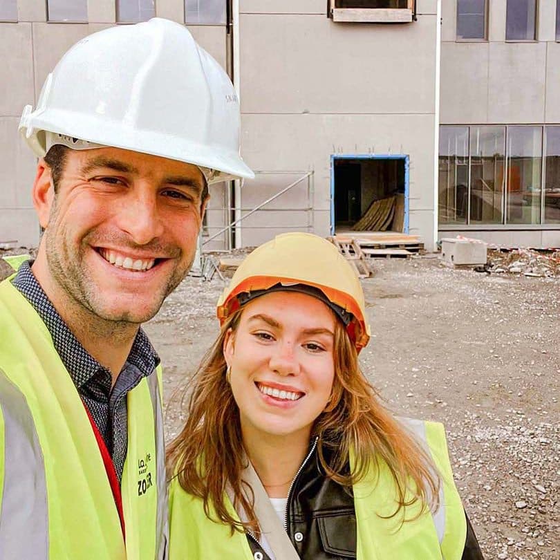 Twee projectleiders met helmen inspecteren de bouw van een coworkingruimte