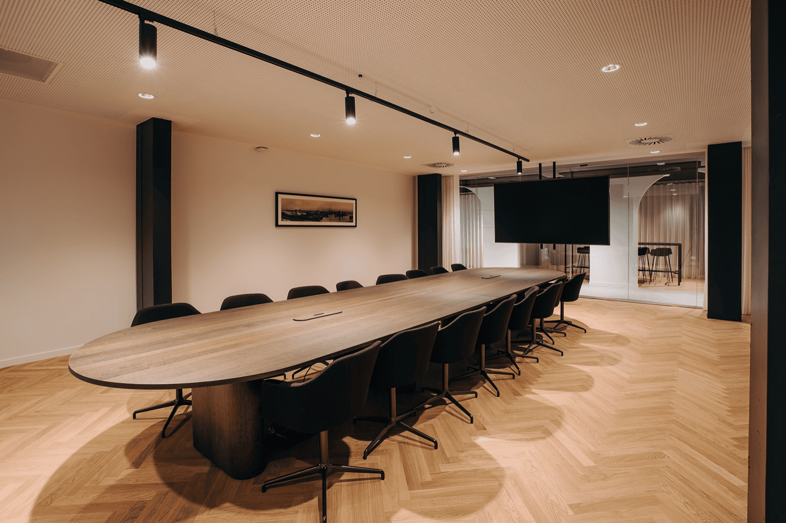 Ruime vergaderzaal met lange houten tafel en warme verlichting