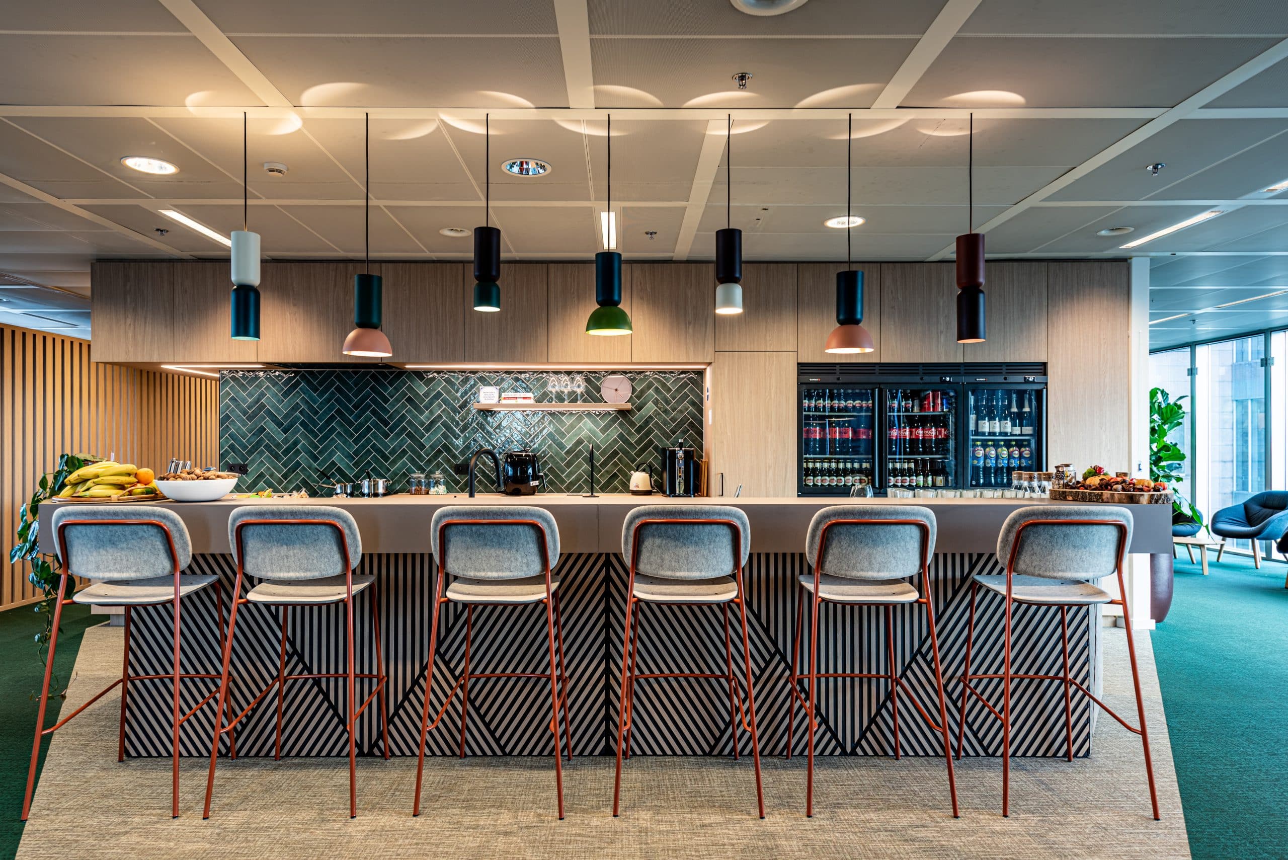 Kantoorbar met warme verlichting en kleurrijke accenten die sfeer en creativiteit versterken