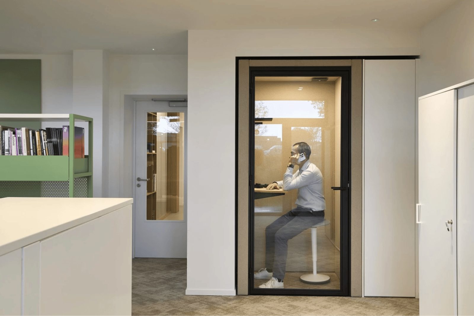 Werknemer voert telefoongesprek in stille belcel als onderdeel van flexwerkplek