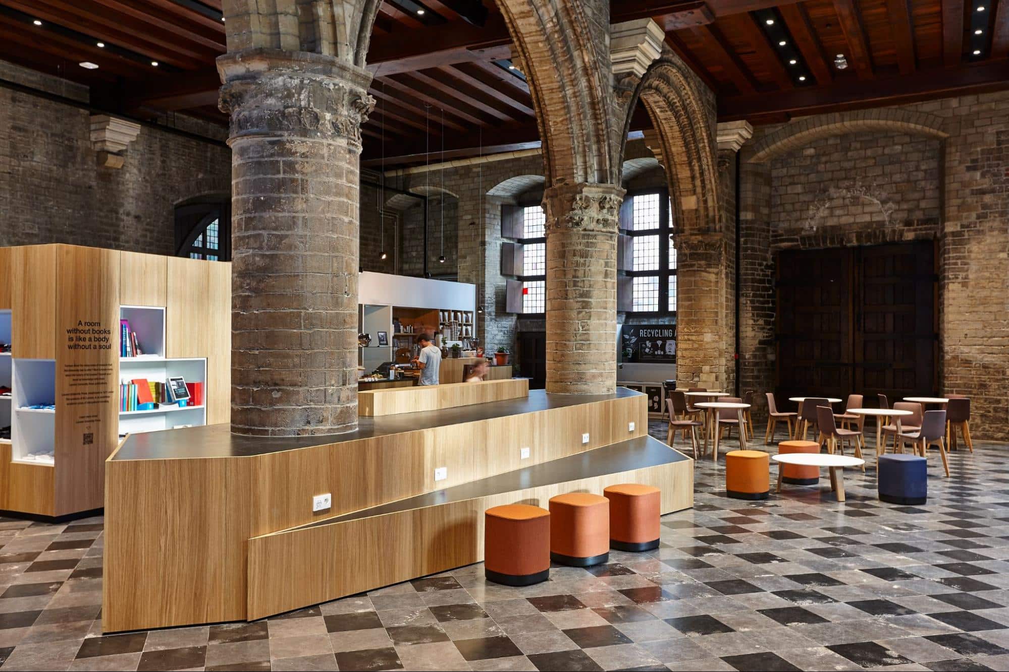 Multifunctionele onderwijsruimte met houten meubels en ontmoetingshoek in historisch gebouw