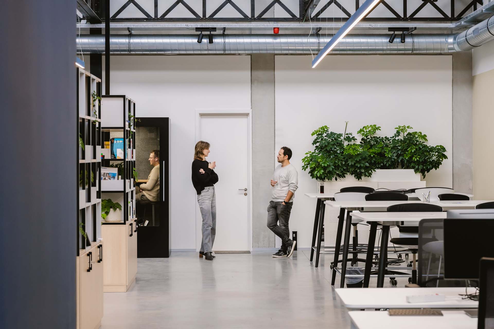 Open ontvangstruimte in een consultancykantoor met flexibele zitplekken en een rustige, professionele uitstraling