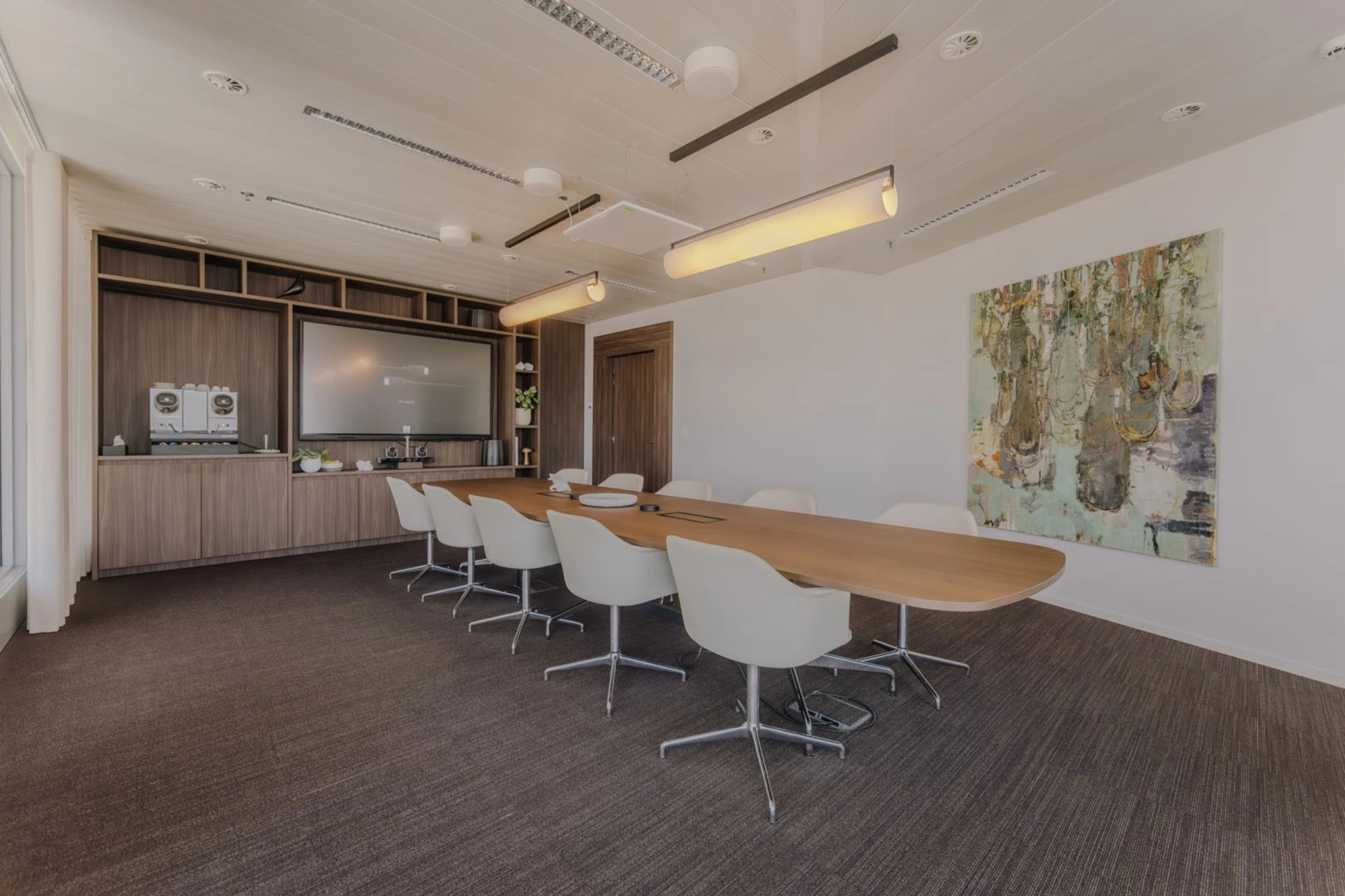 Vergaderruimte in een advocatenkantoor met lange tafel en presentatiescherm voor discrete besprekingen