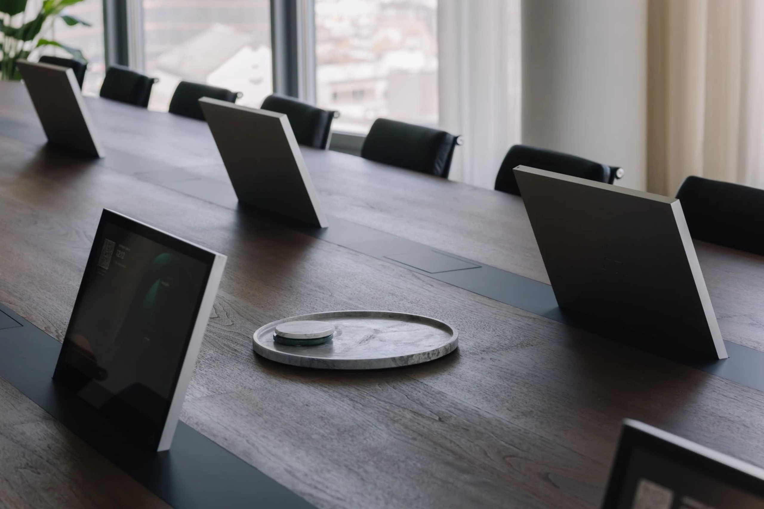 Vergadertafel in een advocatenkantoor met geïntegreerde schermen voor efficiënte en veilige meetings