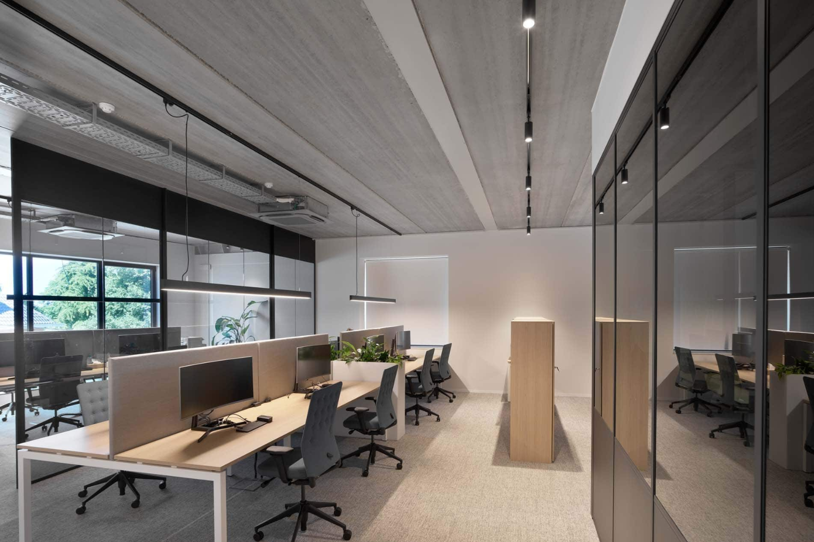 Flexibele werkplekken in een farmaceutisch kantoor met modulaire bureaus, ergonomische stoelen en een open maar rustige indeling