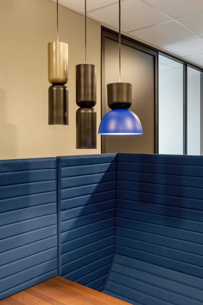 Akoestische overleghoek in een farmaceutisch kantoor met gestoffeerde wanden die rust, discretie en focus ondersteunen