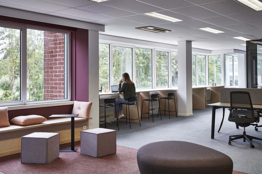 Flexibele werkplek aan het raam met hoge tafels voor geconcentreerd werken in een lichte ruimte