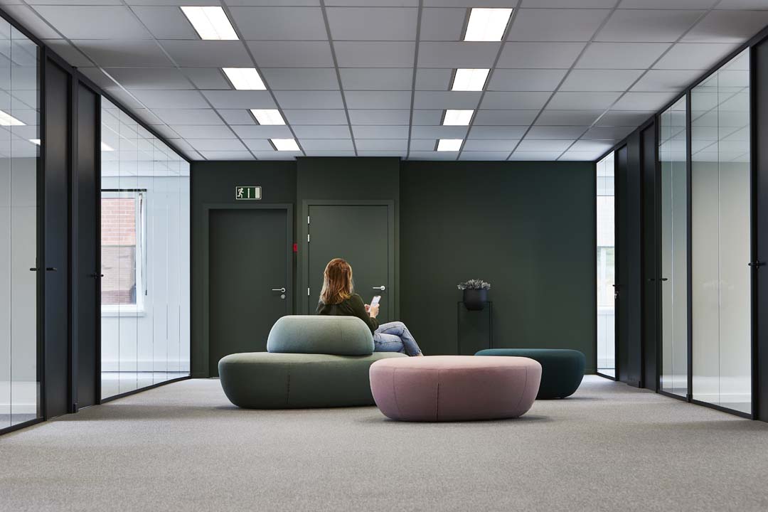 Moderne ontvangstzone met zachte zitmeubels en glazen wanden als voorbeeld van een doordachte kantoorindeling