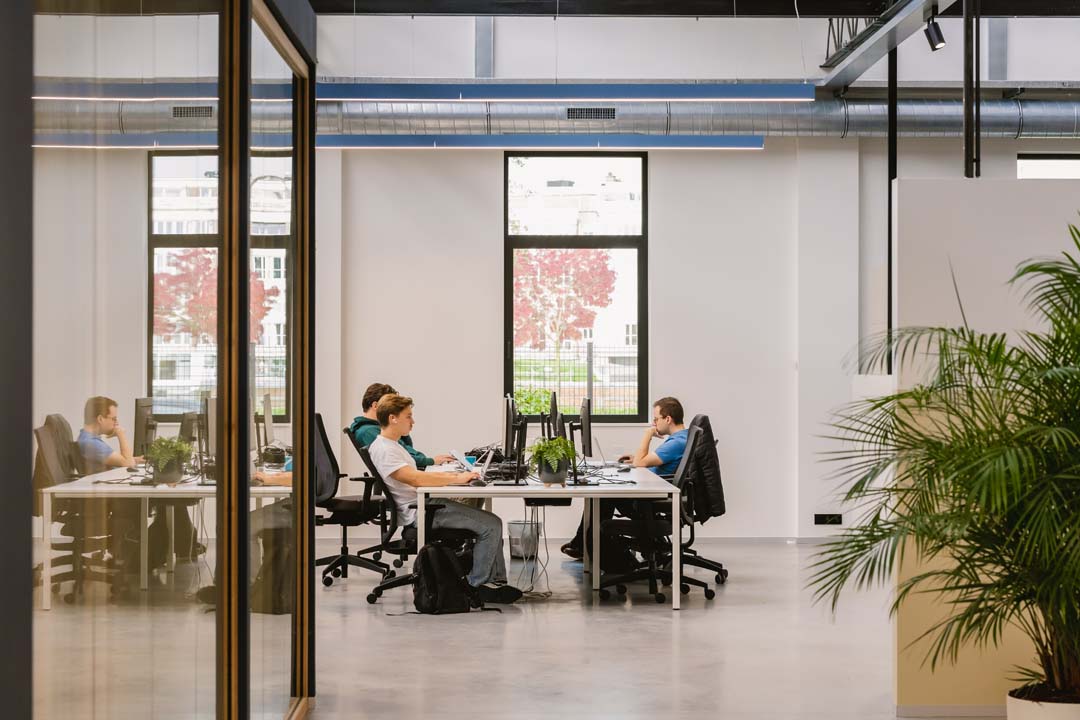 Open werkruimte met gedeelde bureaus en veel daglicht, afgestemd op focus en teamwork
